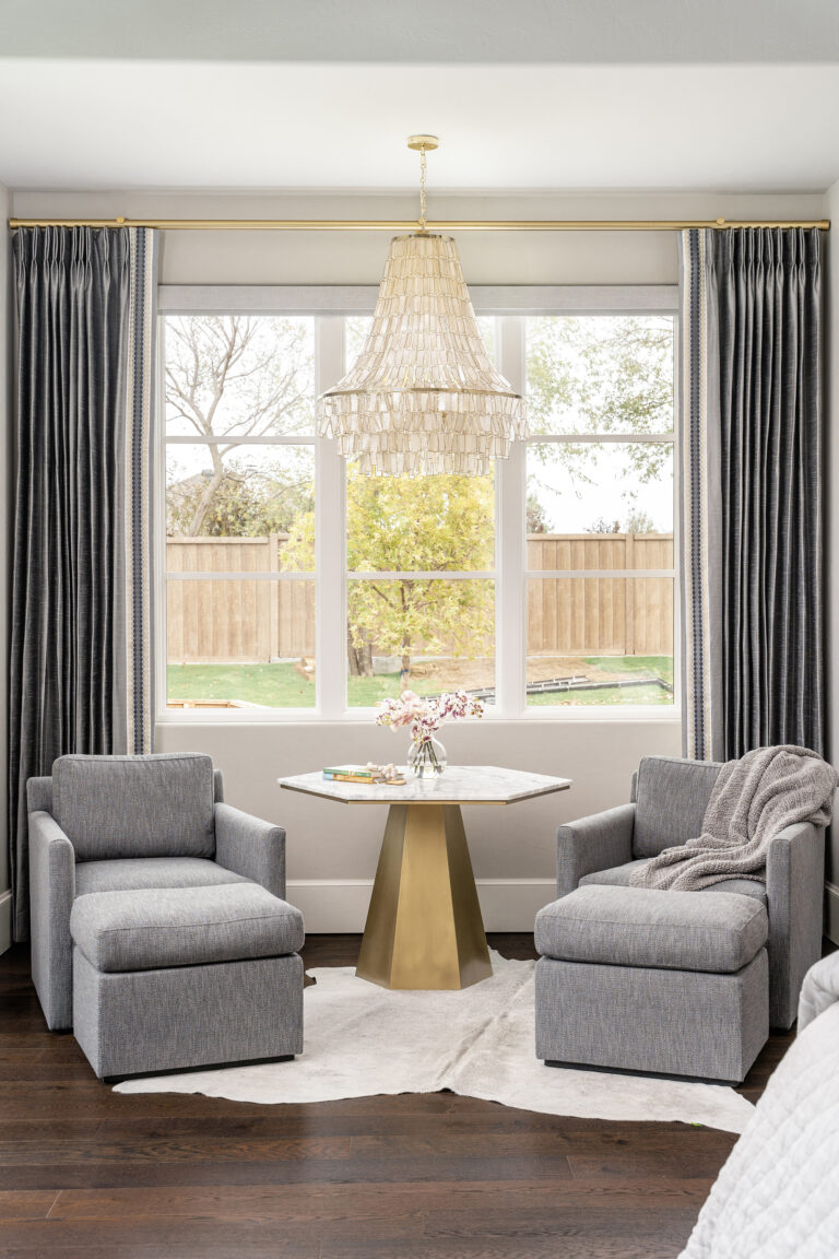 Luxury casual sitting area with two plush chairs custom curtains and a modern table, complemented by an elegant floor lamp