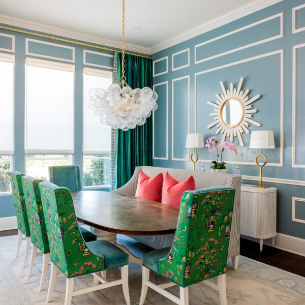 Relaxing dining room ambiance with blue walls and stylish green chairs and color complimenting custom drapery.