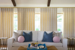 blue, pink and patterned off pillows on comfortable off white sofa
